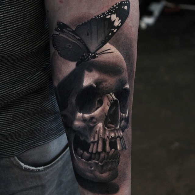 Realistic Butterfly on Skull Arm tattoo