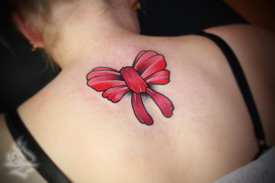 red bow tattoo on back