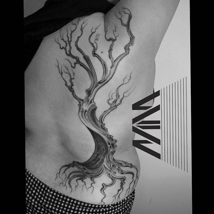 black and grey dead tree tattoo on the side of a body