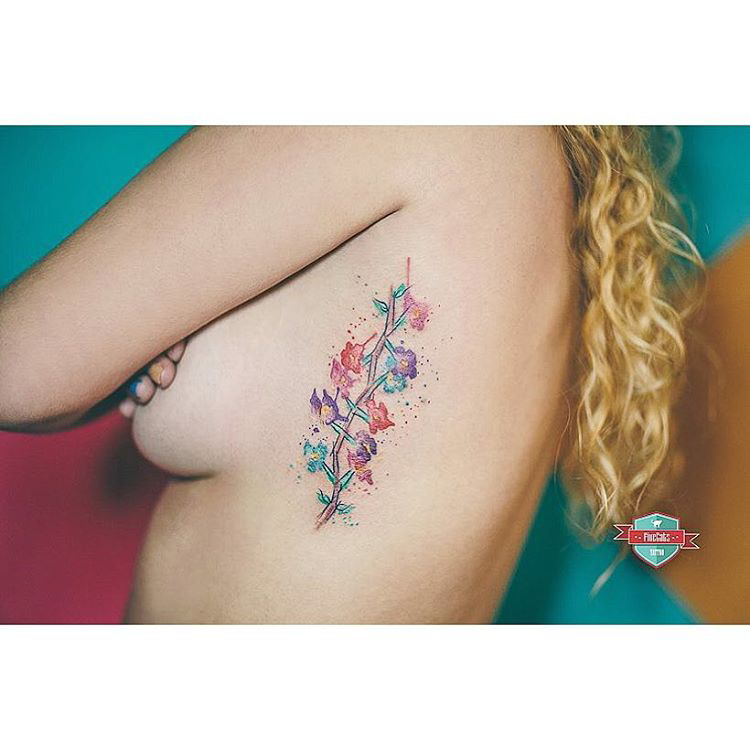 tiny flowers tattoo on ribs watercolor style
