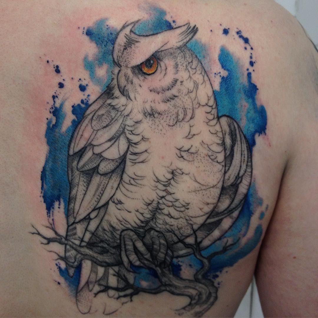 an owl tattoo watercolor style placed on shoulder blade