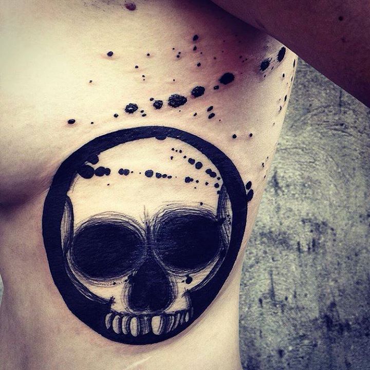 circle skull tattoo on ribs