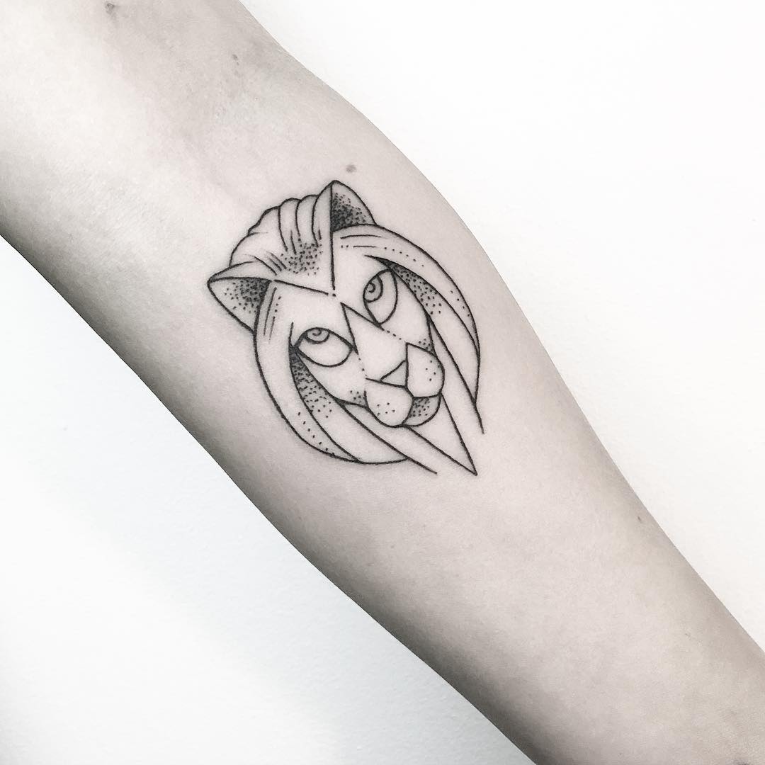 small stylized face of a lion on a forearm
