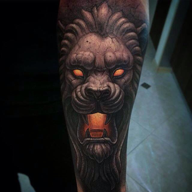 demonic stone lion tattoo on forearm