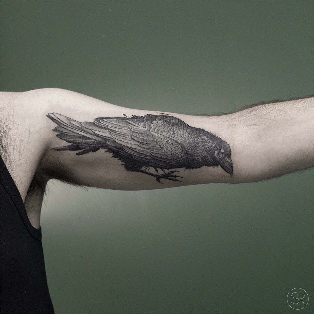 grey raven tattoo on bicep