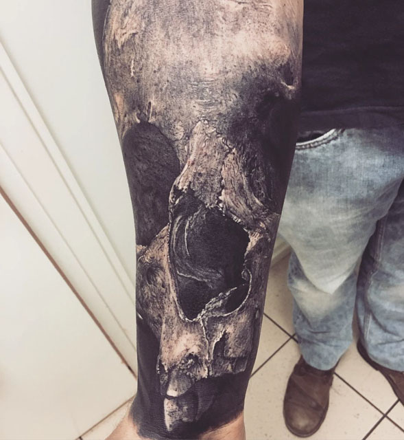 remarkably realistic skull tattoo on full forearm