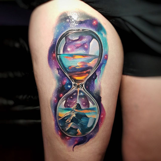 watercolor space hourglass tattoo on thigh