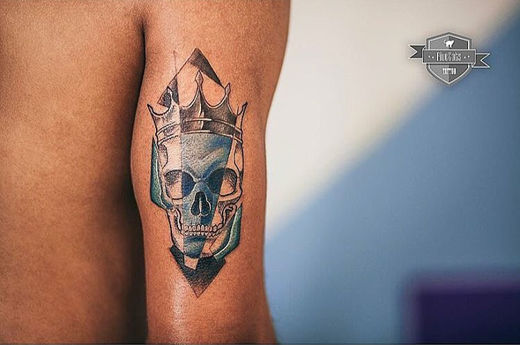 skull with crown tattoo on arm