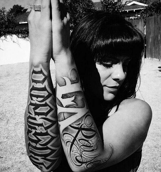 Chicano lettering tattoos on arms