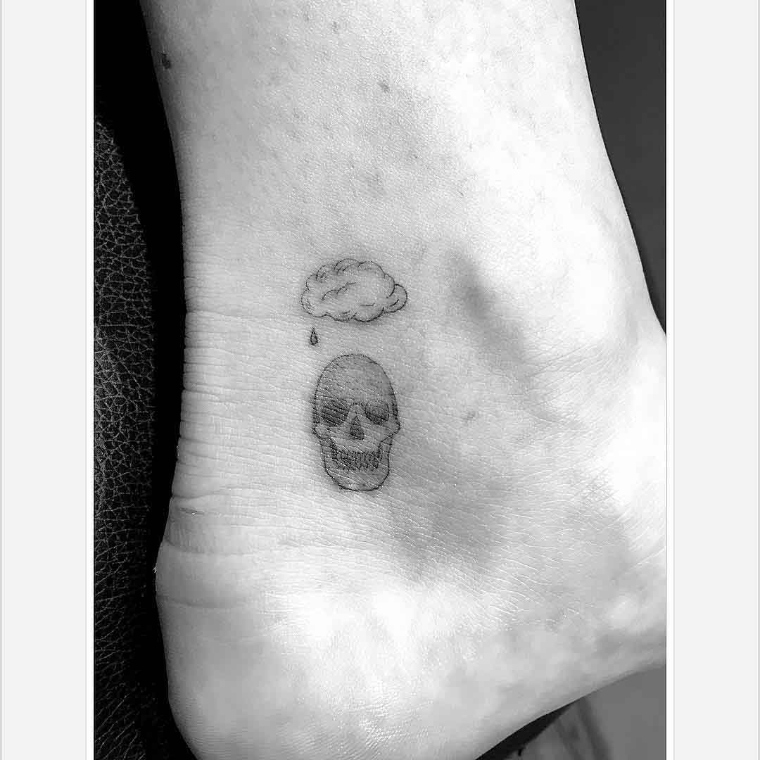 cloud skull small tattoo on heel side