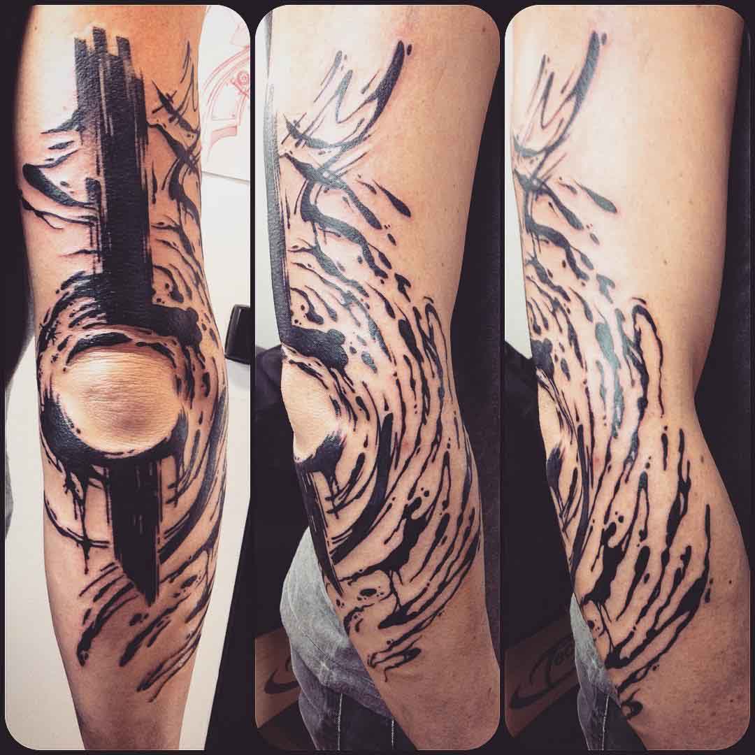 black brush strokes tattoo around elbow