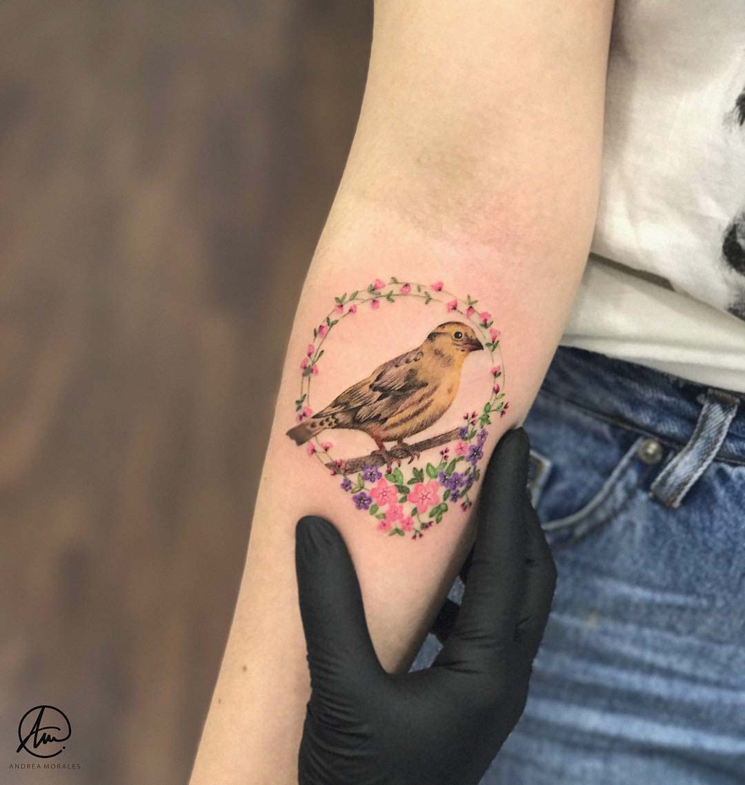 bird in flowers tattoo on arm