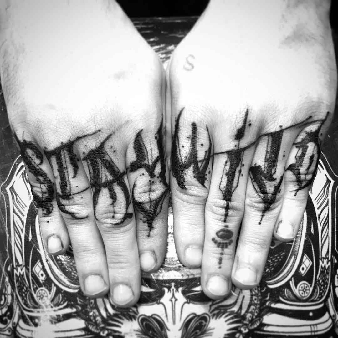 stay wild tattoo on fingers