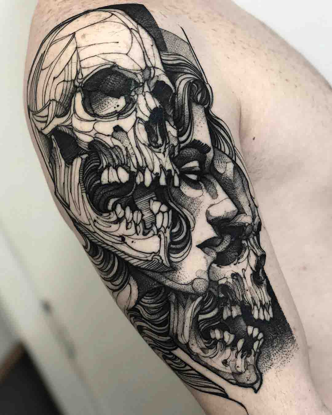 Twos skulls and face tattoo on shoulder